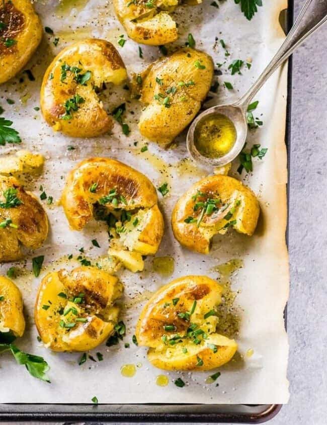 smashed potatoes on a baking sheet with parchment paper