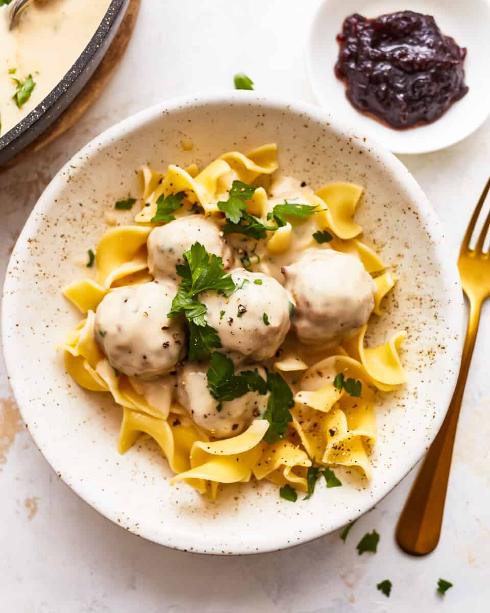 Swedish meatballs in a white bowl with sauce.