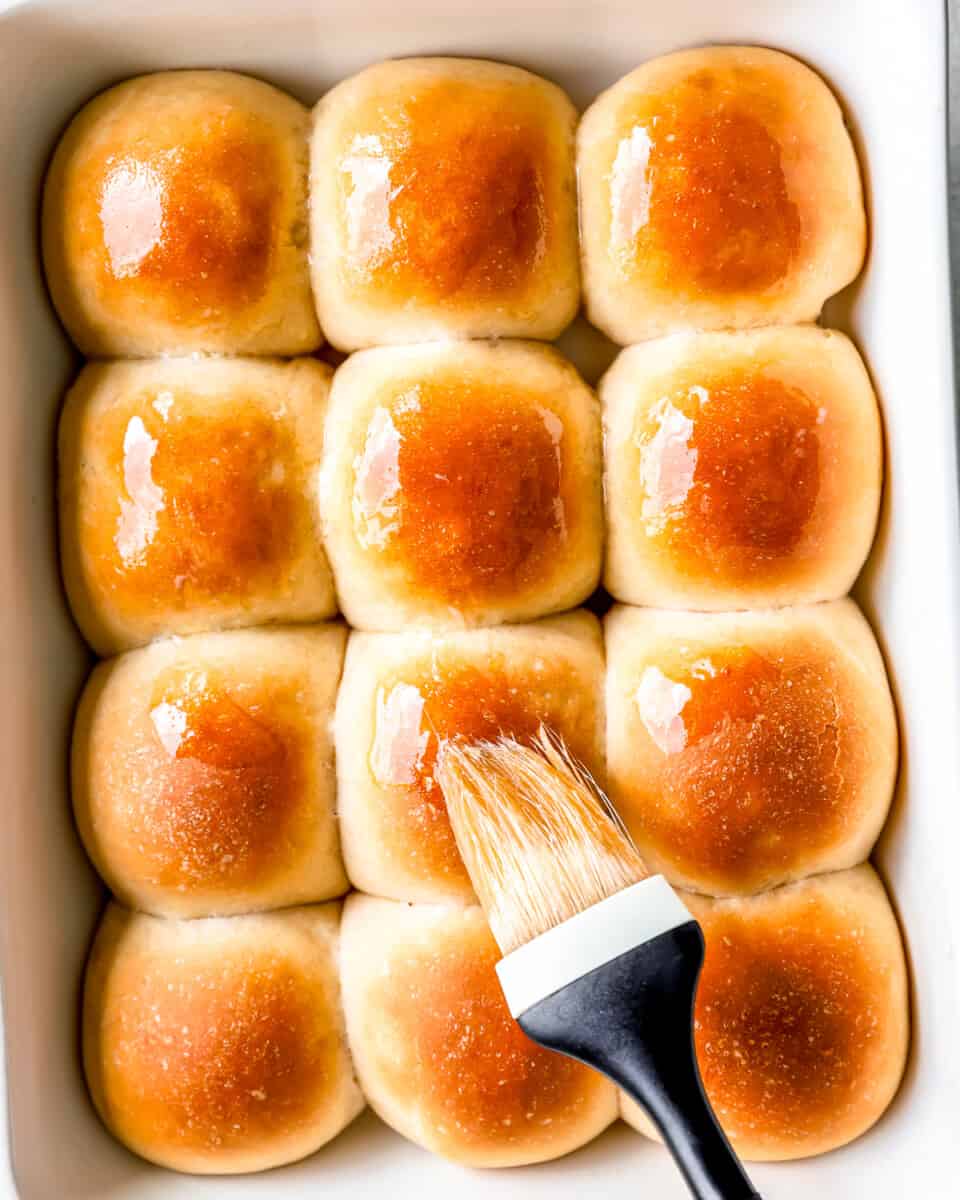 Brushing butter on top of fresh Thanksgiving rolls.