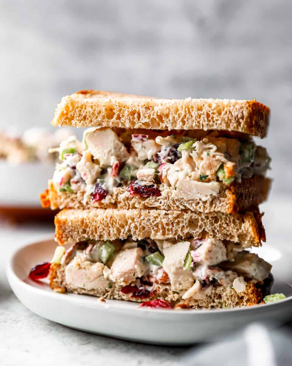 A stack of turkey salad sandwiches on a plate.