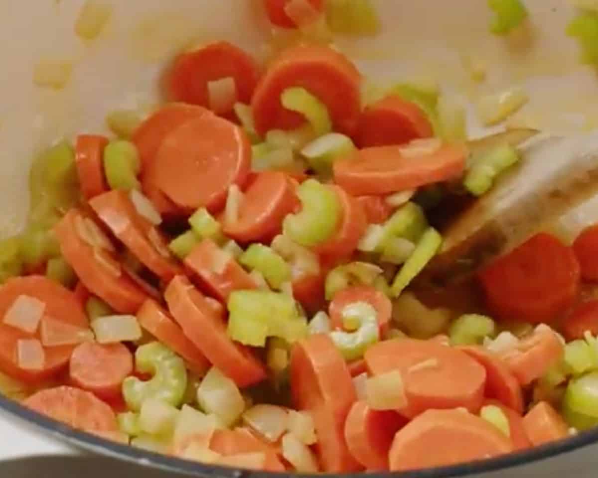 Sliced carrots, celery, and diced onion sautéing in a Dutch oven with butter and oil - 6
