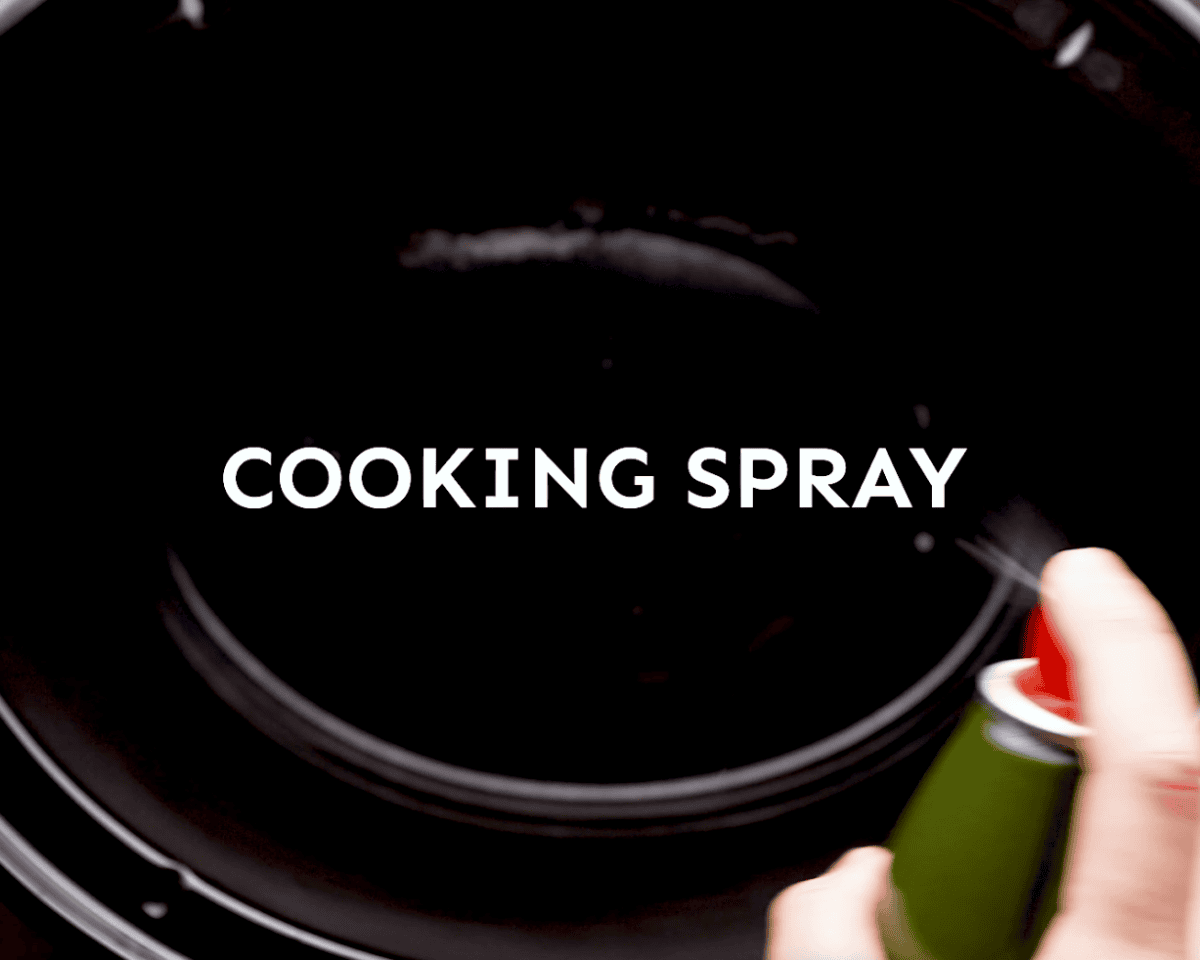 spraying a slow cooker with cooking spray