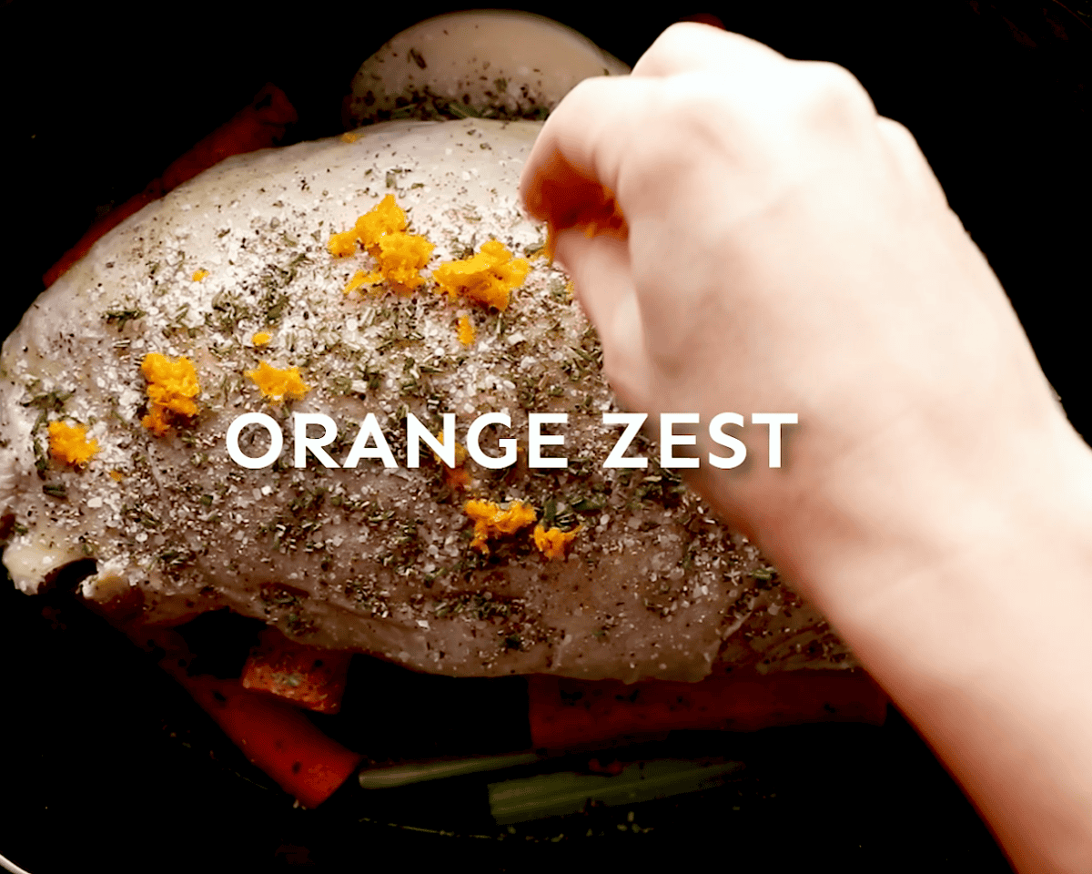 orange zest being sprinkled to season a turkey