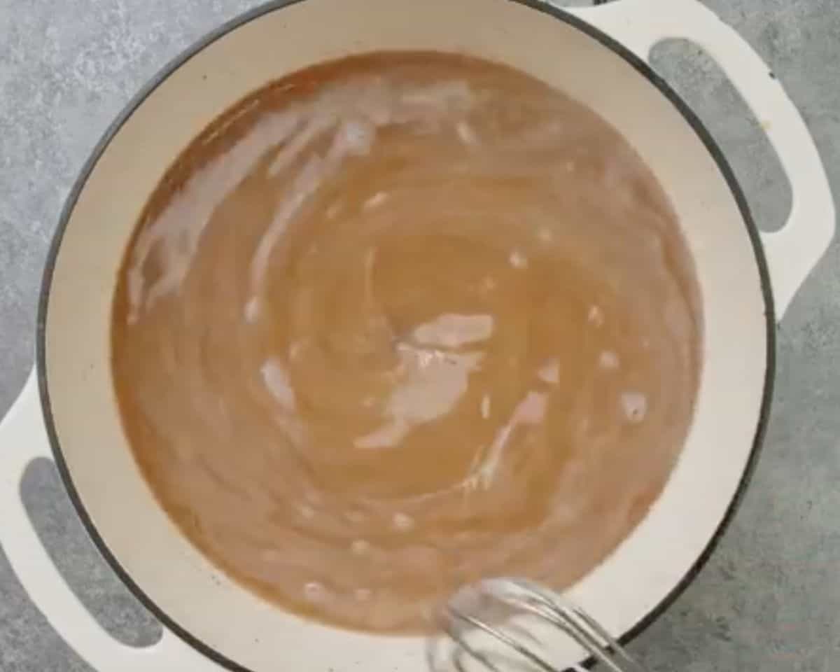 Beef broth being whisked into the roux to create a smooth, creamy soup base - 10