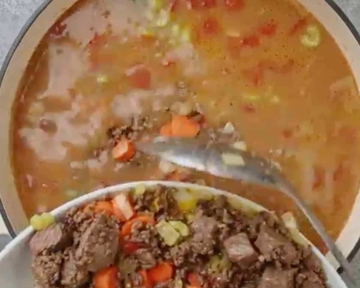 Cooked steak and vegetables being returned to the thickened soup broth - 11
