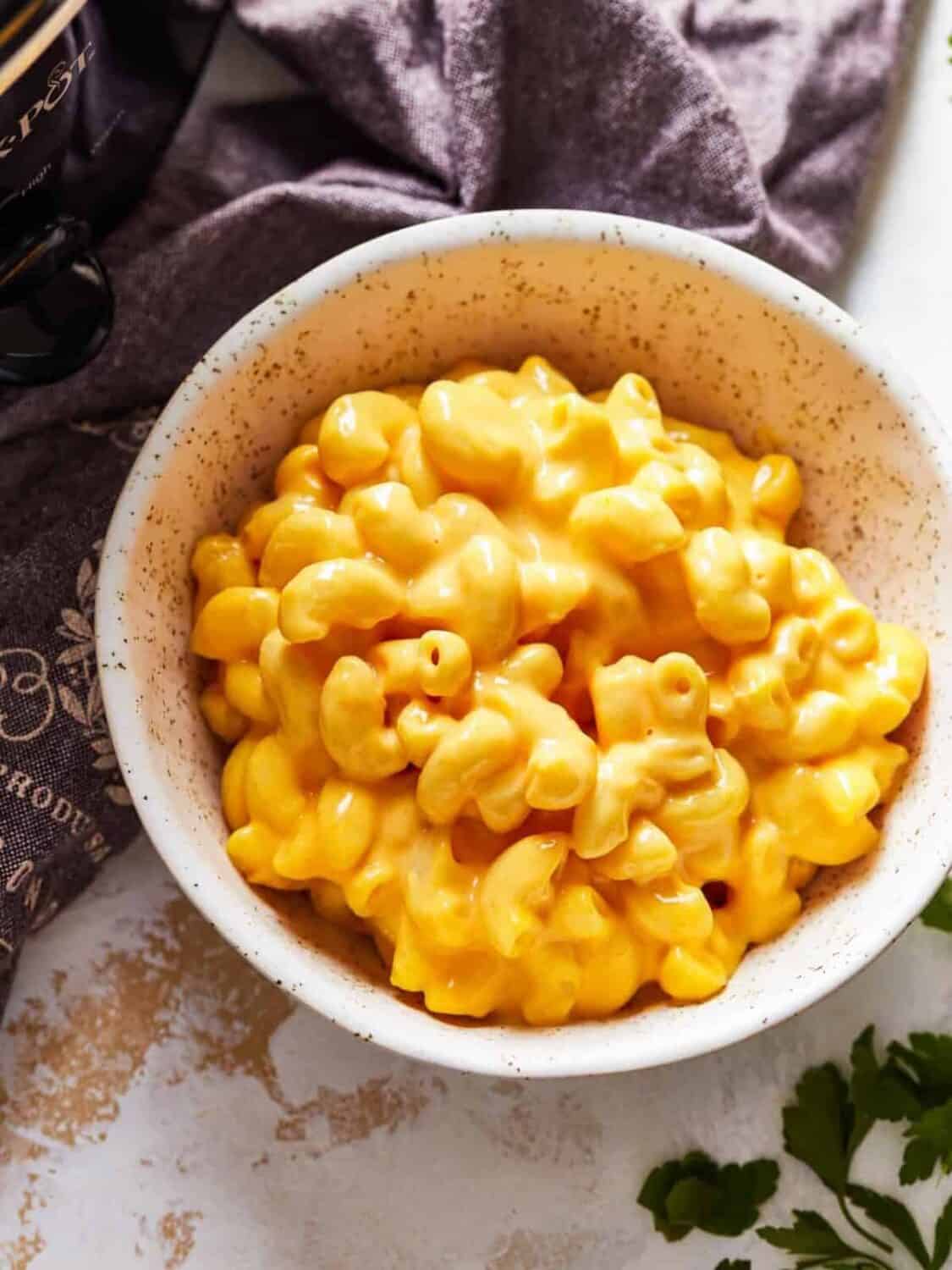Crock Pot Mac and Cheese is a super simple recipe! This easy slow cooker macaroni and cheese makes the perfect side dish or weeknight dinner. It's virtually fool proof and comes out extra creamy and extra cheesy every time. Mac n cheese is always one of the best cheesy comfort foods around! Close up crockpot mac and cheese in a bowl.
