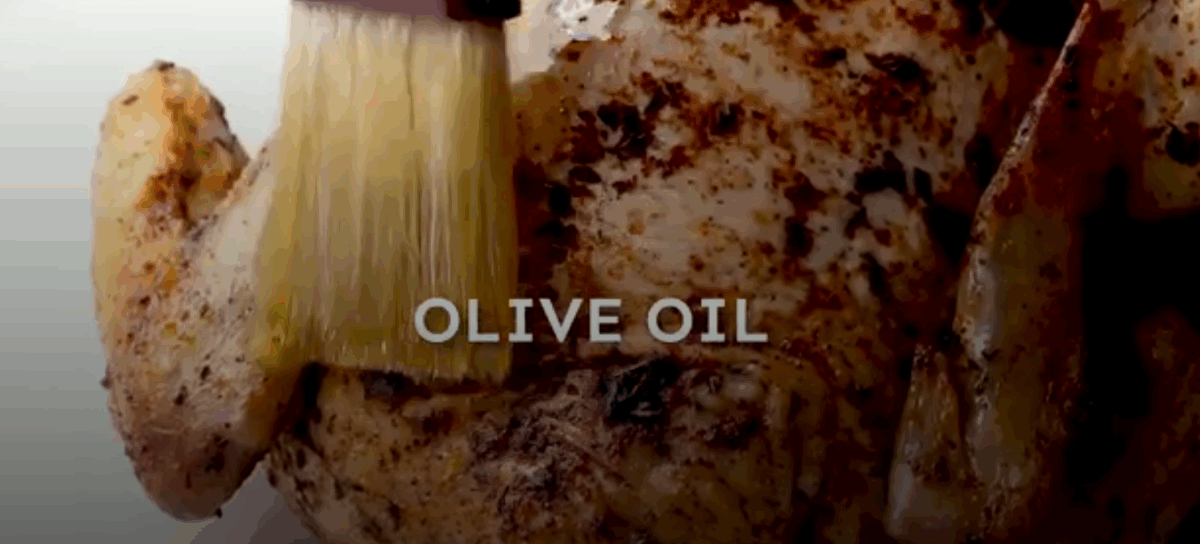 Brushing the chicken with olive oil. 