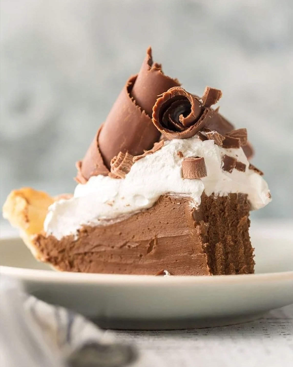 A slice of French silk pie on a white plate.
