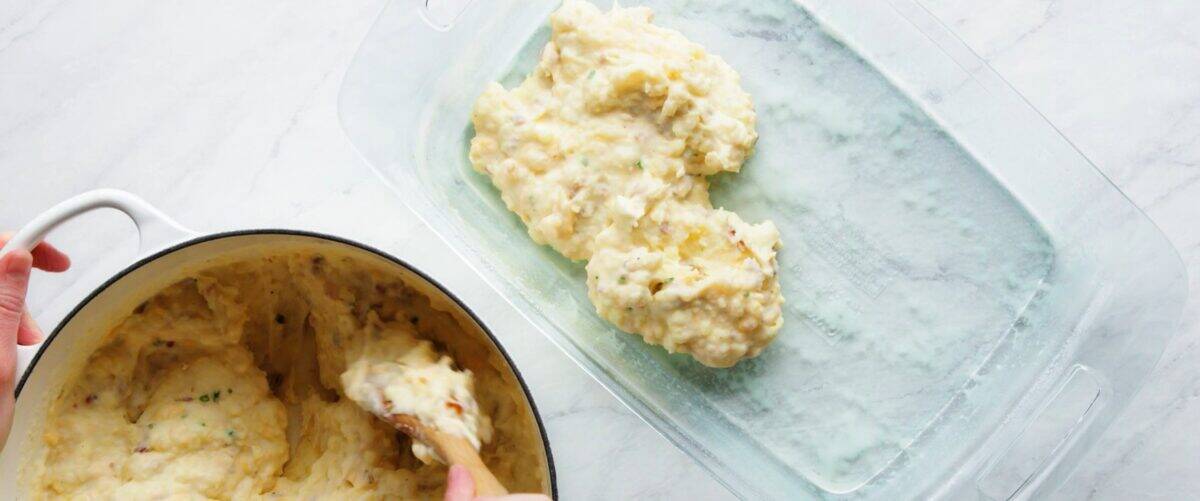 Transferring the mashed potato mixture to the casserole dish.