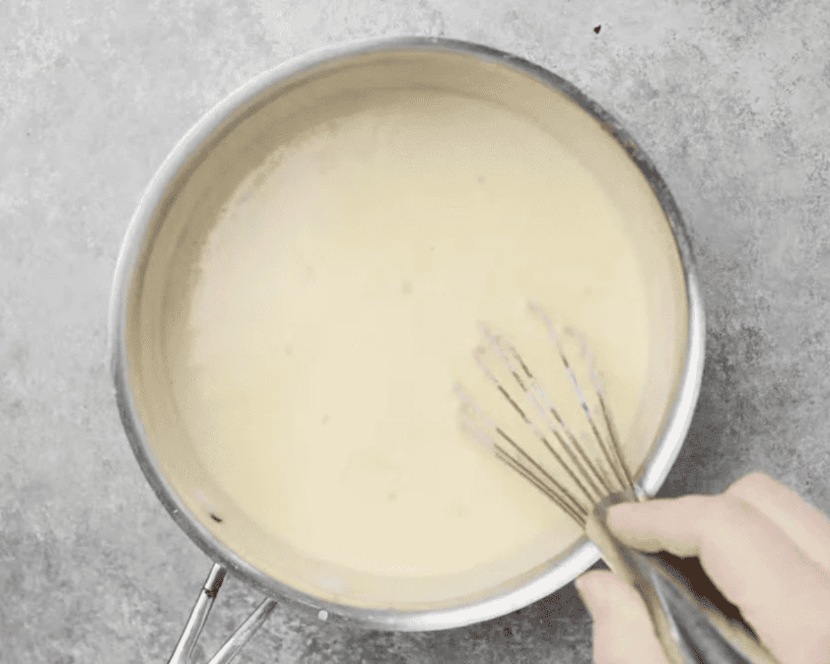 Adding cheese to the sauce.