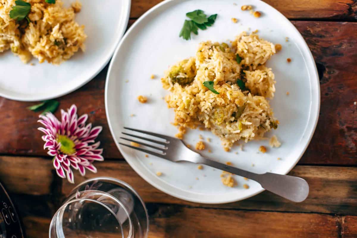 Two plates of Velveeta broccoli rice casserole on a wooden table.