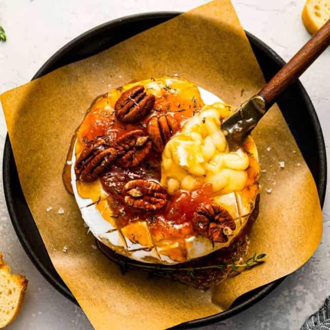 A plate with cheese and pecans on it.