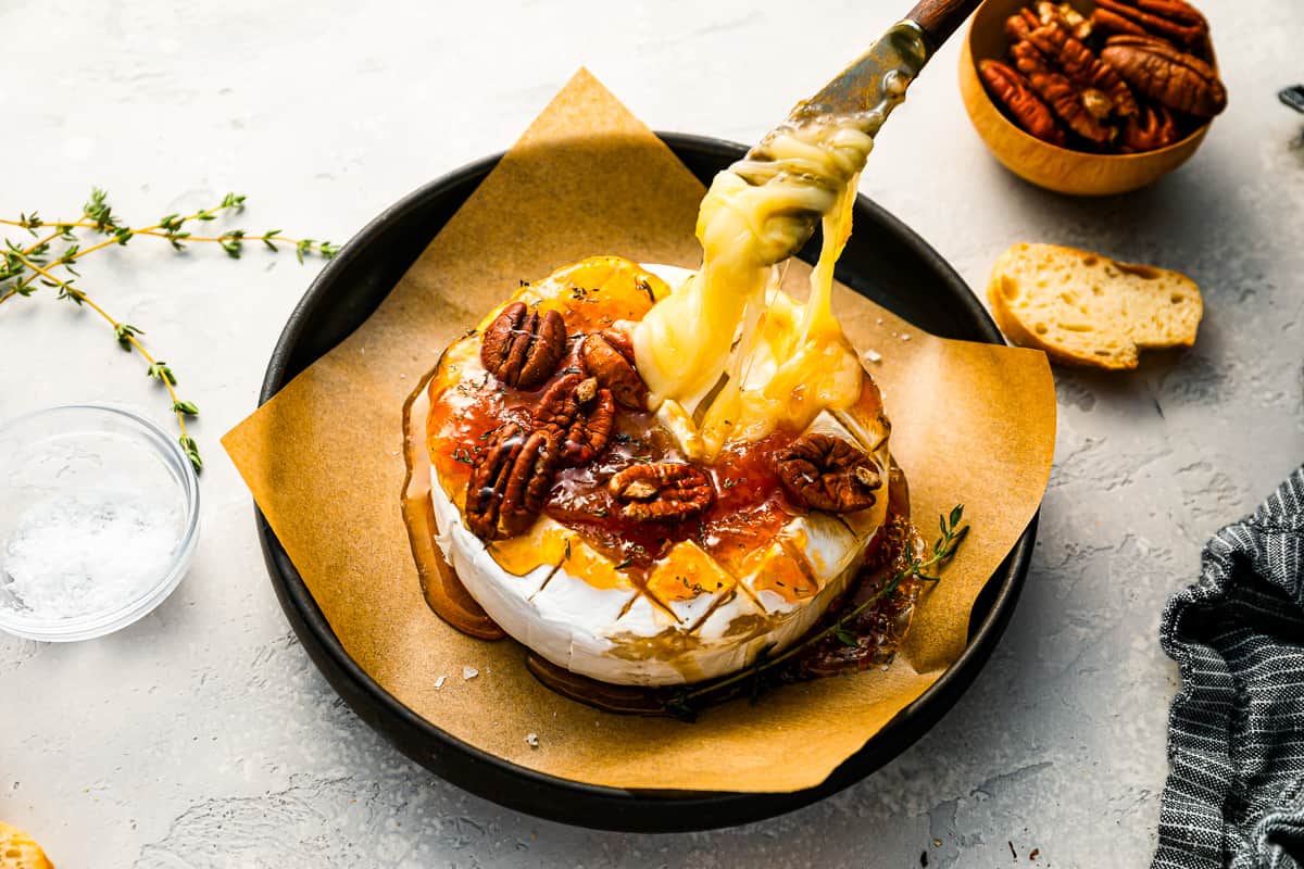 A cheesecake with pecans and nuts on a plate.