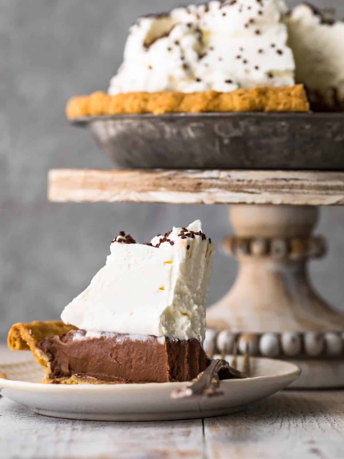 A delectable slice of the best chocolate cream pie garnished with whipped cream on a plate.