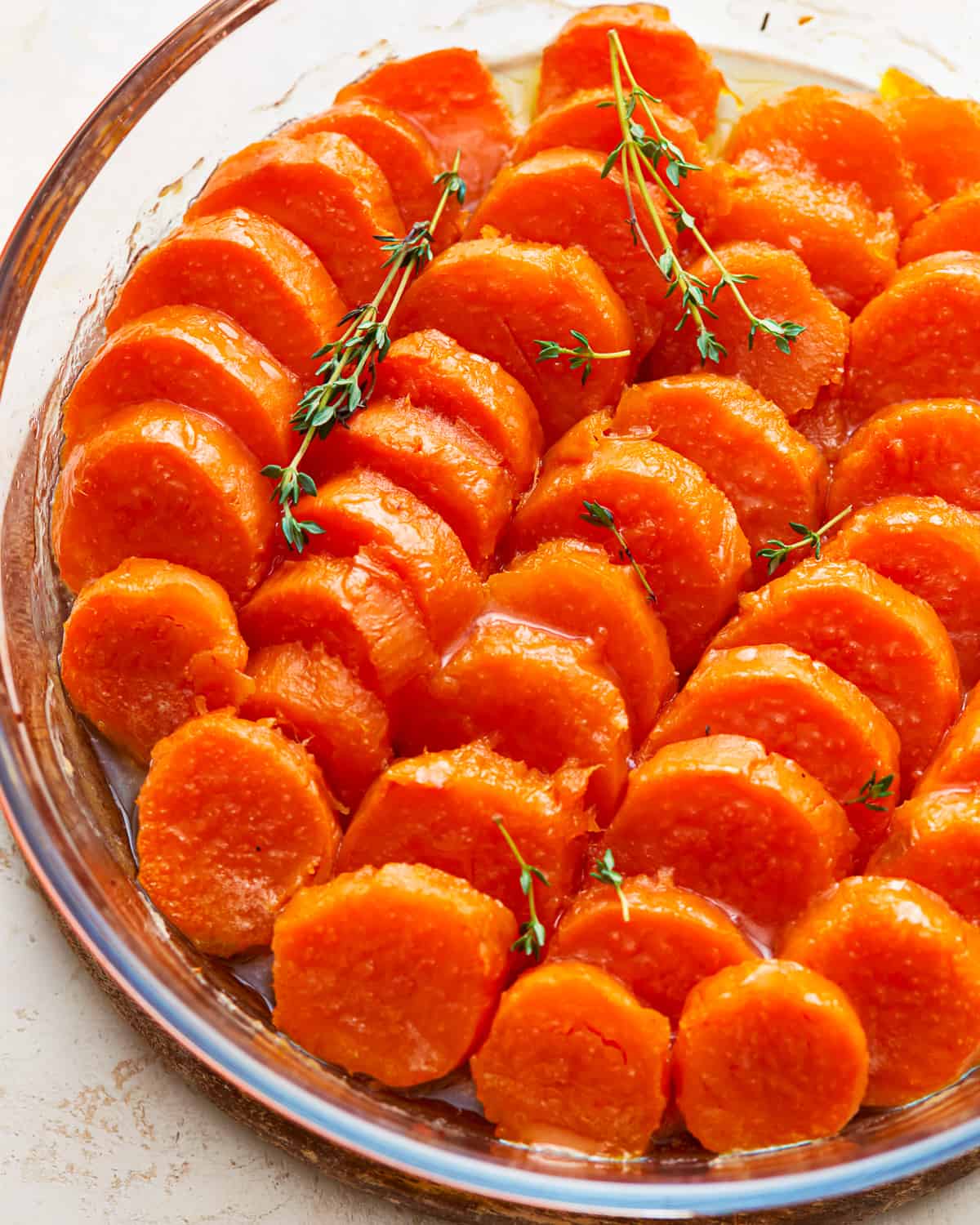 A glass dish with candied sweet potatoes in it.