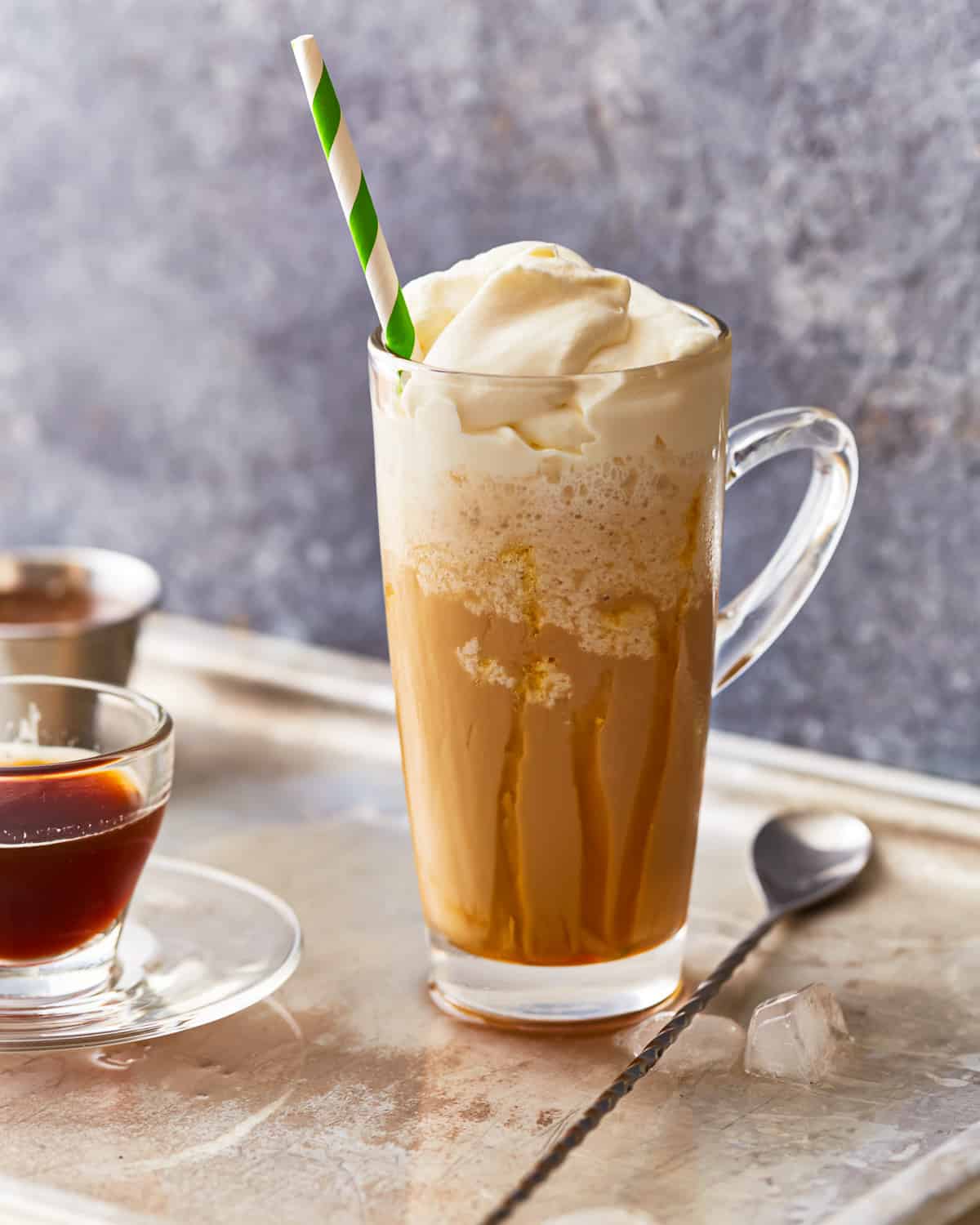 Caramel Frappuccino in a glass with a straw.
