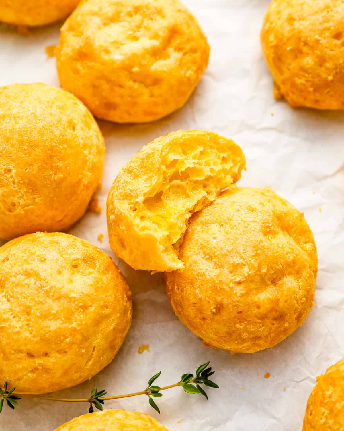 A tray of French cheese puffs (gougeres) with a bite taken out of them.