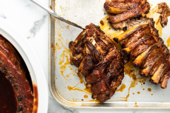Slow cooker ribs on a baking sheet with a fork.