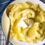 creamy mashed potatoes in a bowl with butter and a spoon