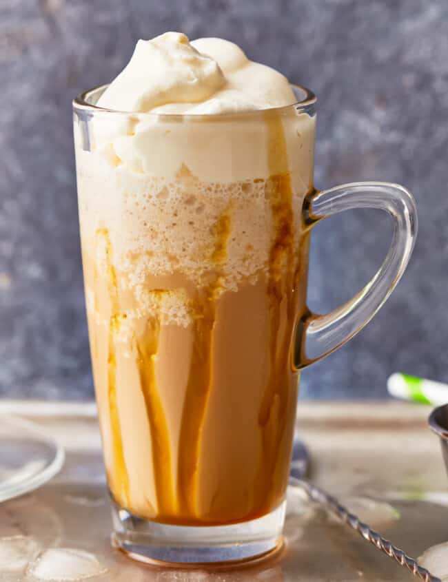 homemade Caramel Frappuccino in a clear glass, topped with whipped cream.