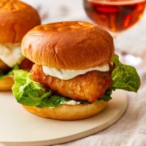 Two fish sliders on a plate with a glass of beer.