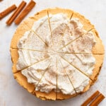 A no bake pumpkin pie cheesecake with whipped cream and cinnamon.