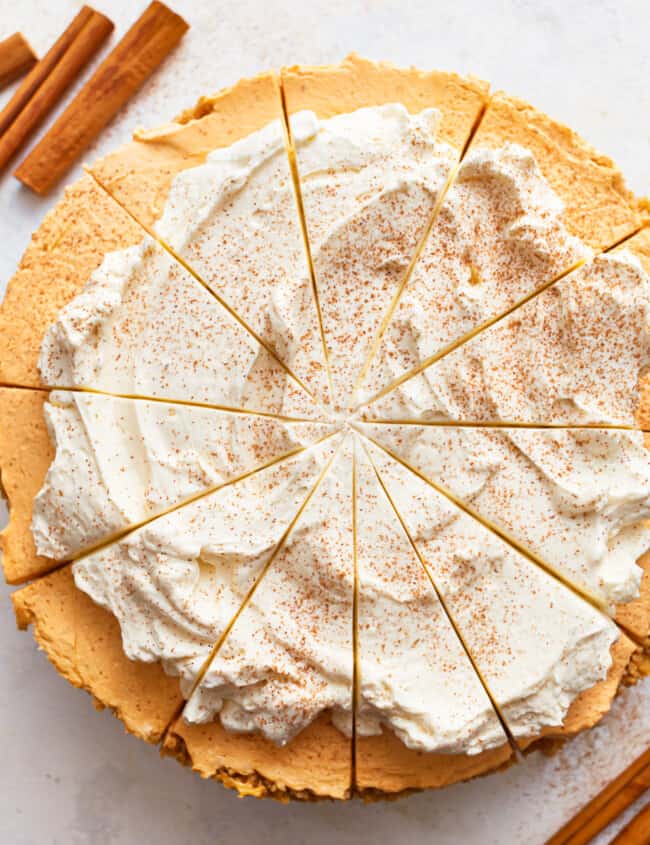 A no bake pumpkin pie cheesecake with whipped cream and cinnamon.
