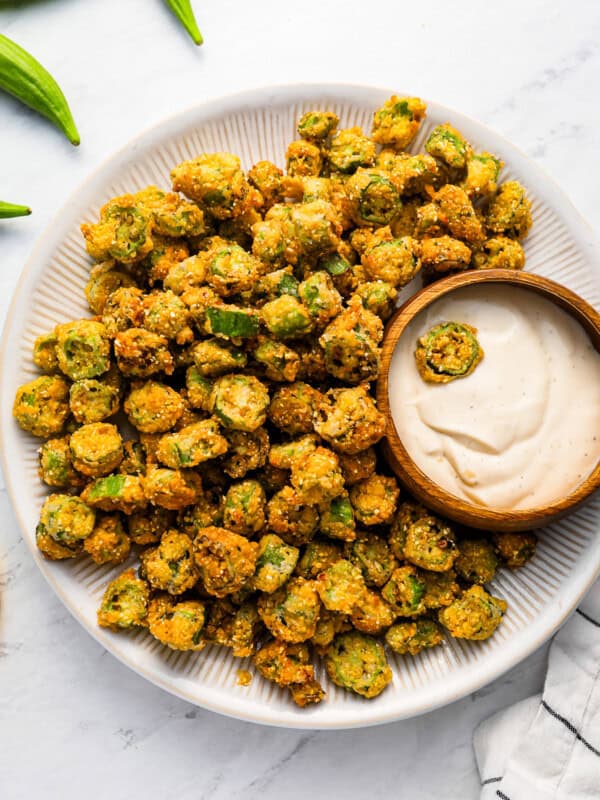 A plate of fried okra with dipping sauce.