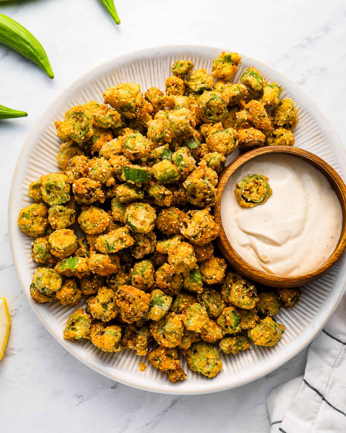 A plate of fried okra with dipping sauce.