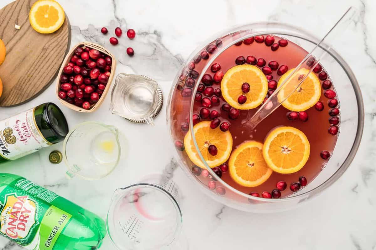 overhead image of holiday punch in a glass bowl with orange slices and cranberries