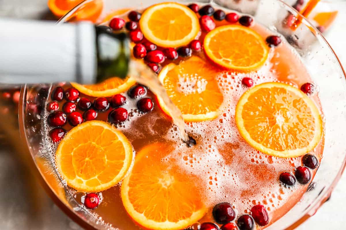 A bowl filled with oranges and cranberries.