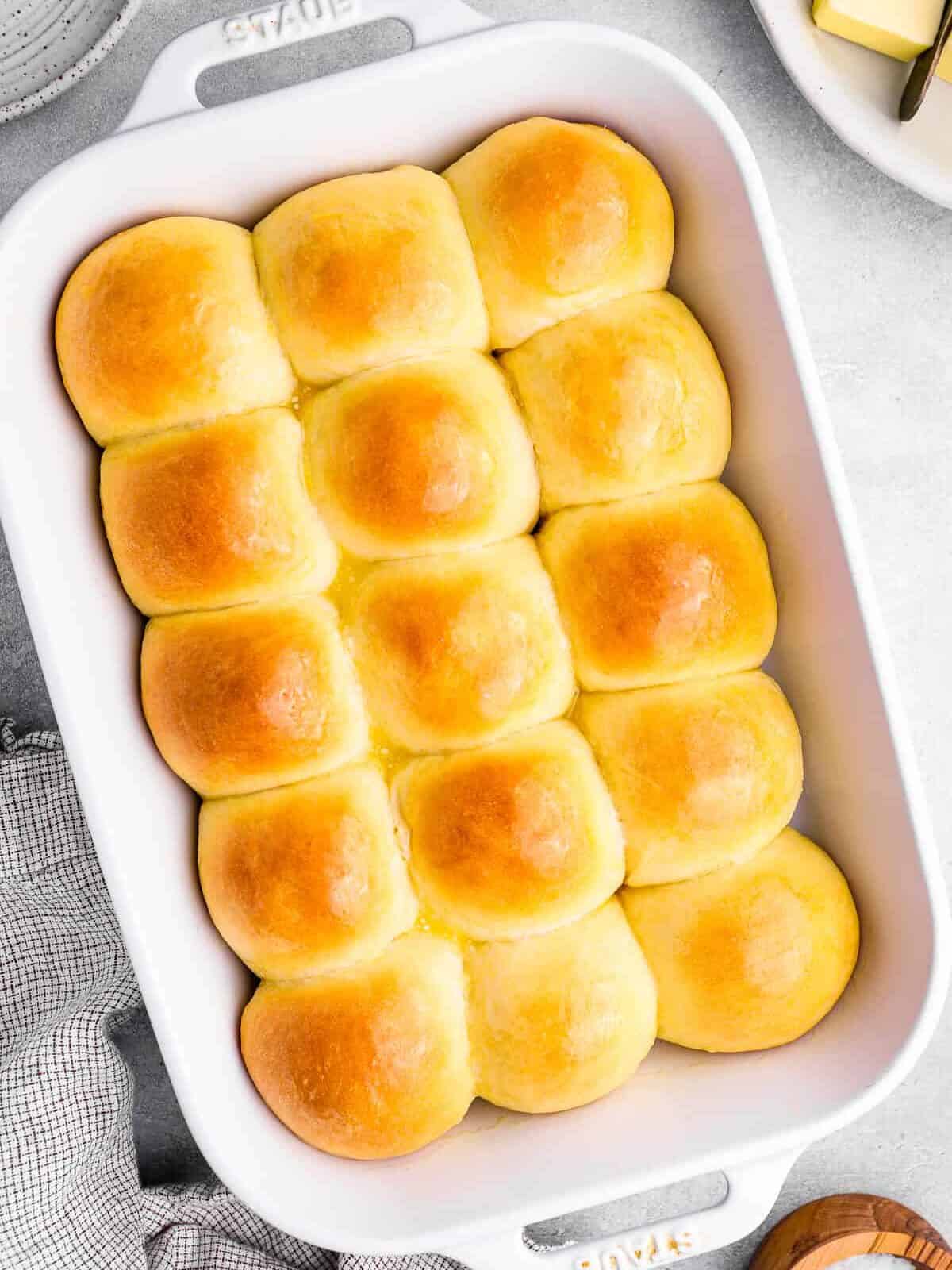 overhead view of 15 dinner rolls in a white baking dish.