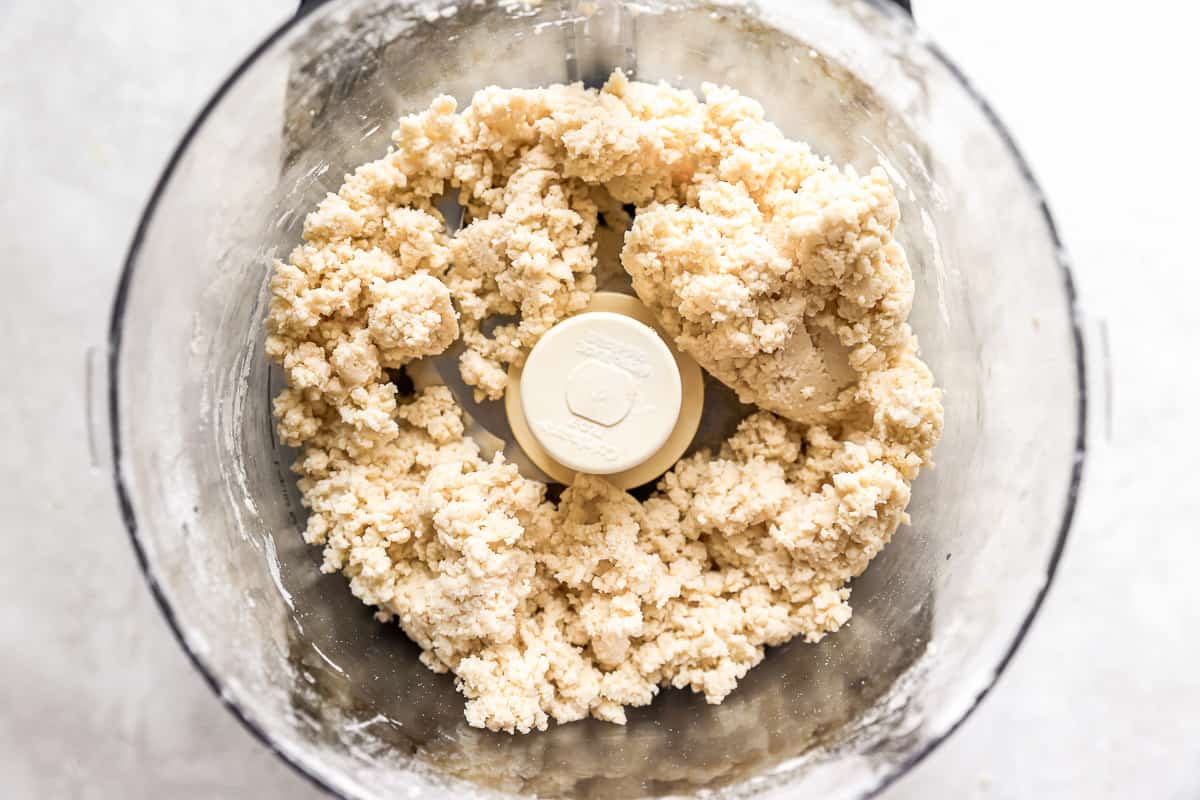 A food processor with a bowl full of crumbs.