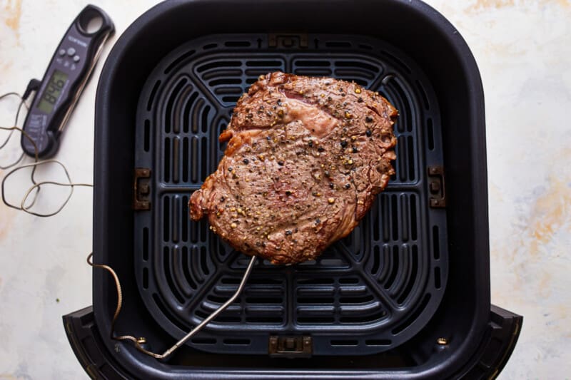 An air fryer with a meat in it.