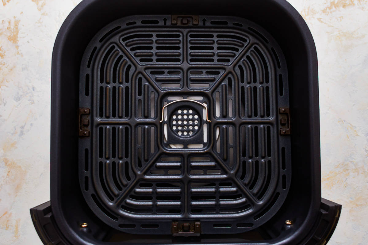An air fryer grate on top of an inverted white bowl.