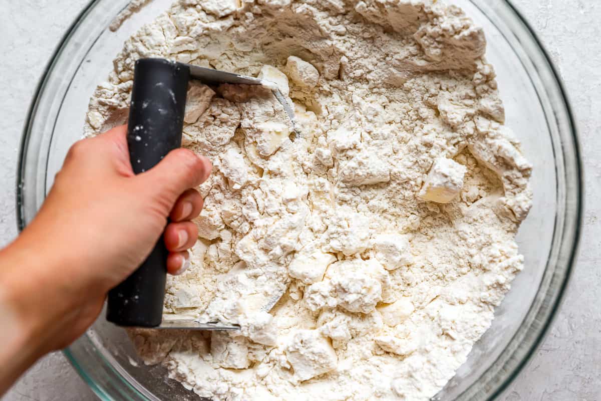 A person mixing flour in a bowl.