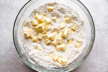 A glass bowl filled with flour and butter.