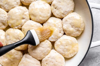 A person using a spatula to stir biscuits in a pan.