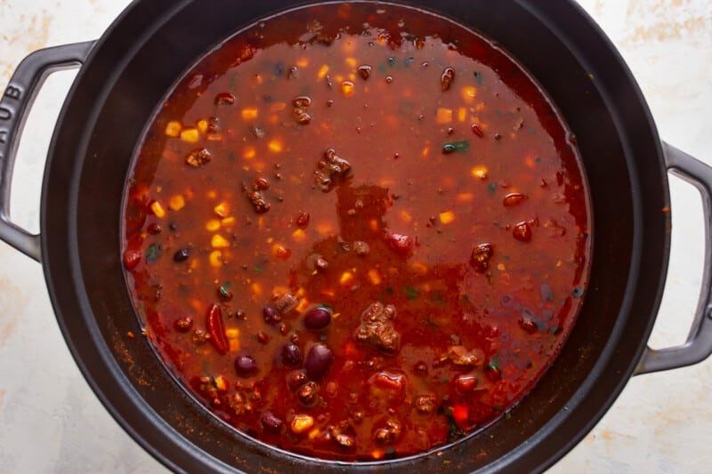 A pot of beef tortilla soup with beans and corn in it.