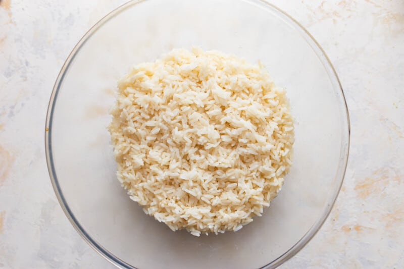 Rice in a glass bowl on a white surface.