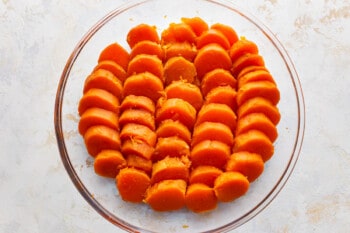 Sliced sweet potatoes in a glass baking dish.