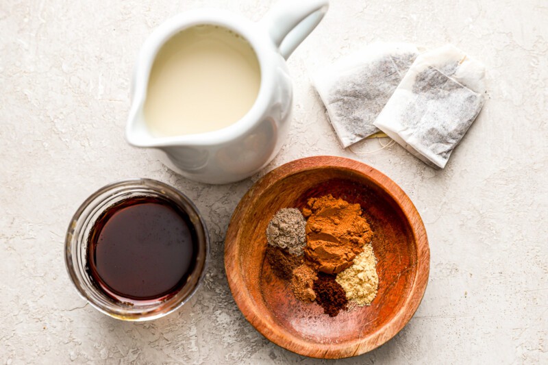 A wooden bowl with spices and milk on a table.