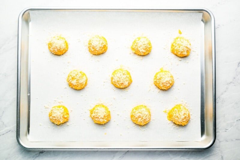 cheese puff dough lined up on a baking tray.