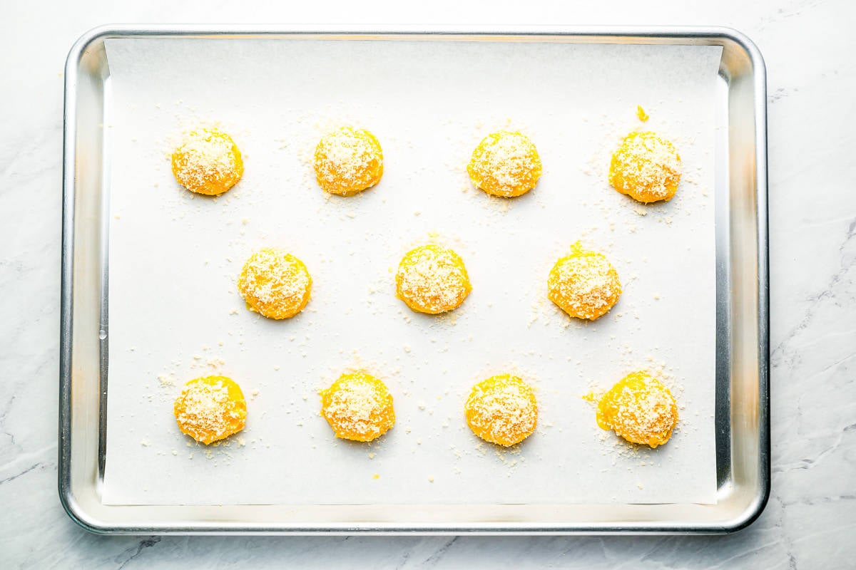 cheese puff dough lined up on a baking tray.