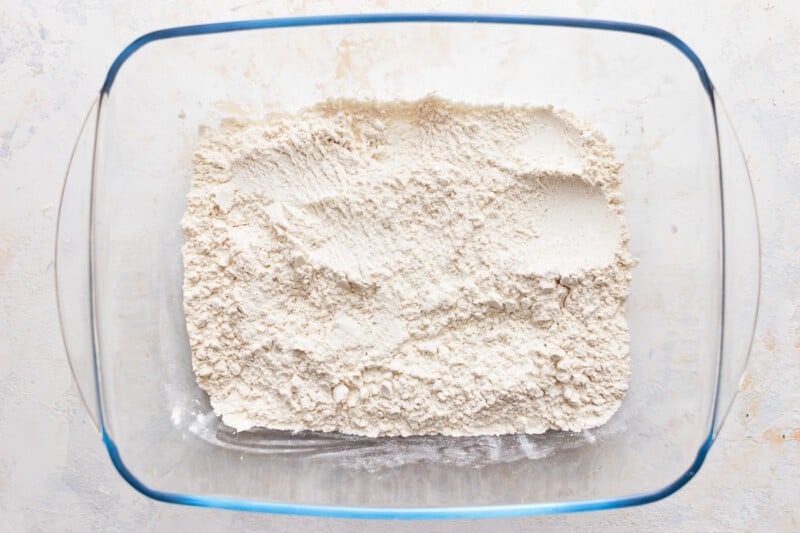 Flour in a glass bowl on a white background.