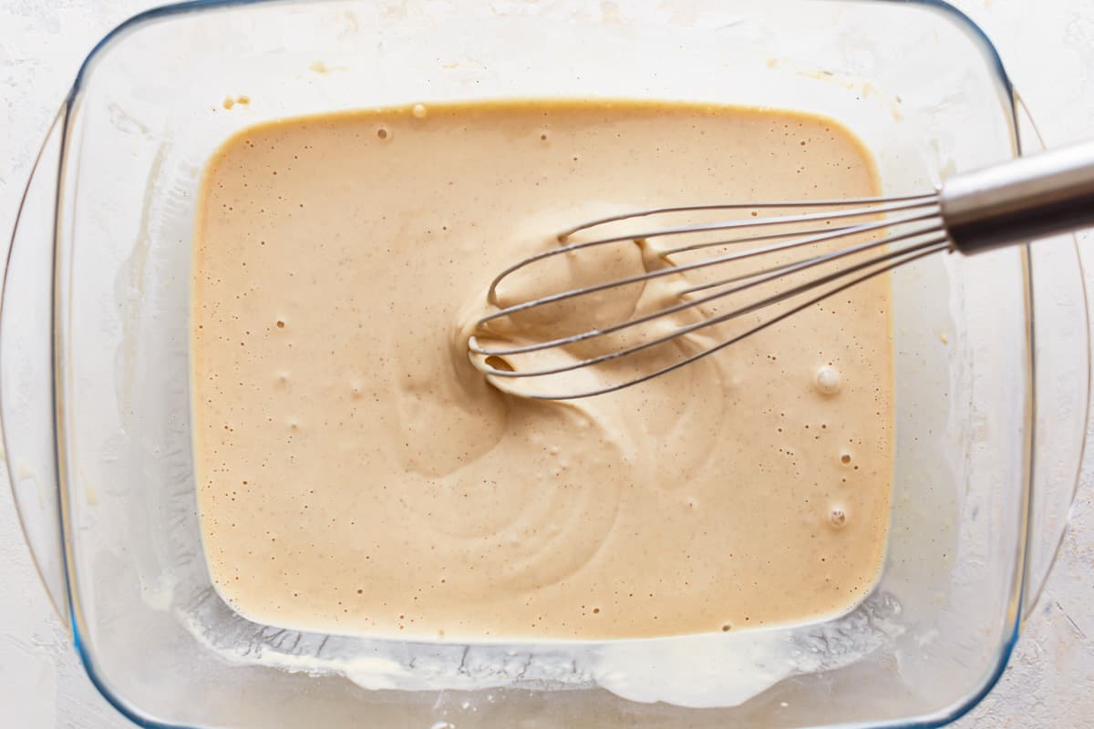 Whisking ingredients in a dish to make a beer batter.