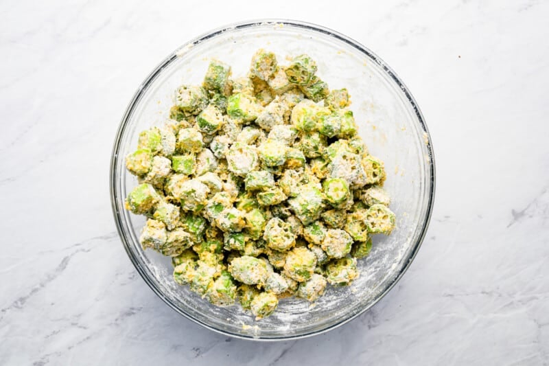 A bowl filled with a mixture of greens and cheese.