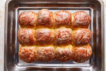 A baking pan filled with a variety of meatballs.