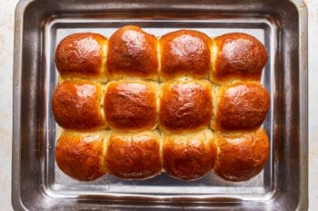 Buns in a baking pan on a white background.