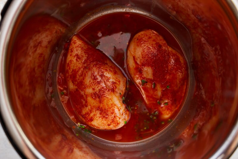 An instant pot filled with chicken in a red sauce.